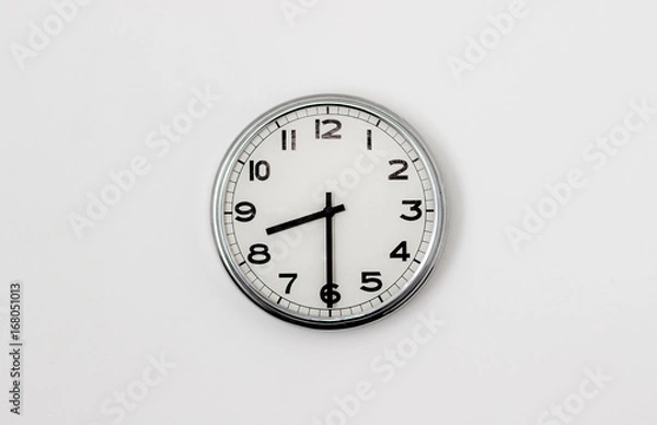 Fototapeta White Clock hanging on a white wall showing time 8:30