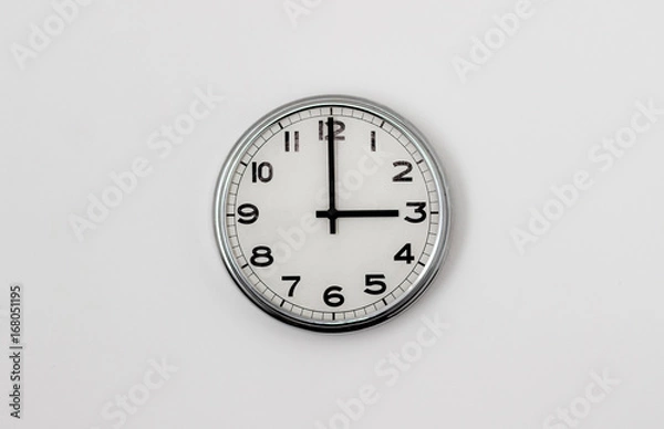 Fototapeta White Clock hanging on a white wall showing time 3:00