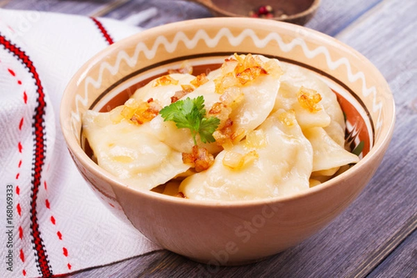 Fototapeta Varenyky, vareniki, pierogi, pyrohy or dumplings, filled with potato and served with salty caramelized onion