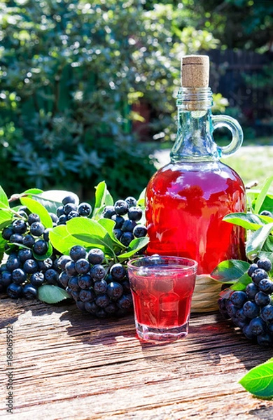 Fototapeta A glass of tincture of chokeberry. Free space for your text. Wooden background.