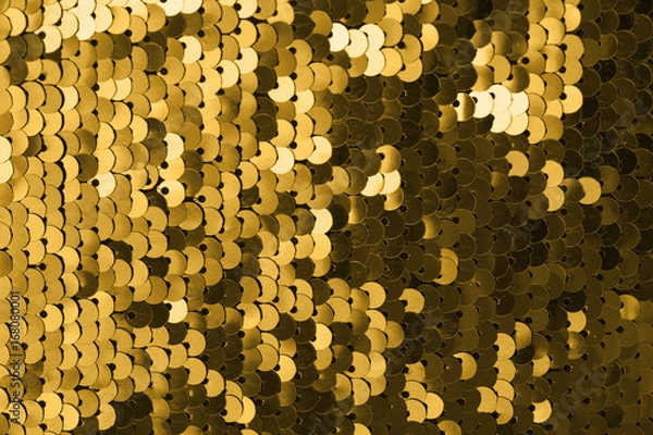 Fototapeta Sequins close-up macro. Abstract background with gold sequins color on the fabric. Texture scales of round sequins with color transition .