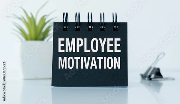 Fototapeta A black notebook with the words Employee Motivation written on it