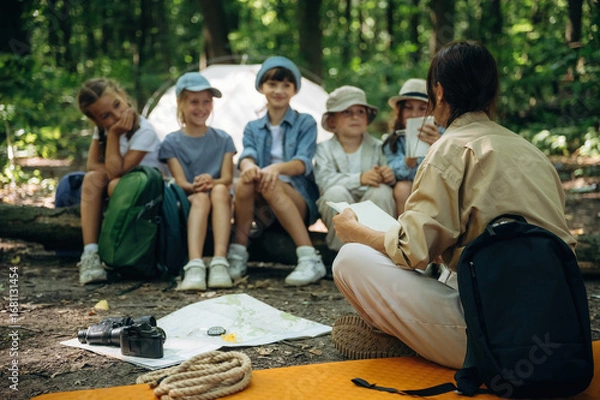 Obraz It's the story time. Woman is doing tour for group of kids in the forest