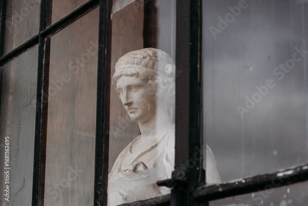 Obraz ancient statue set on a window