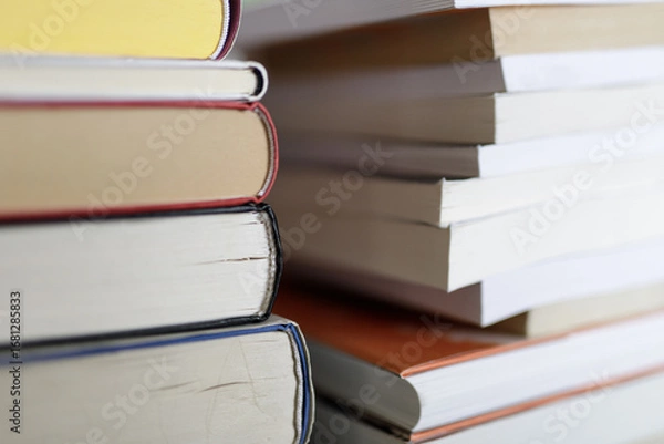 Fototapeta Close-up image of a stack of books, representing education, knowledge, learning, and literature. Perfect for educational or library concepts.