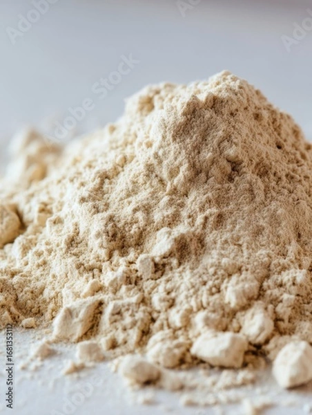 Fototapeta Close up studio shot of a pile of protein powder on a white surface showing its texture and consistency for nutrition