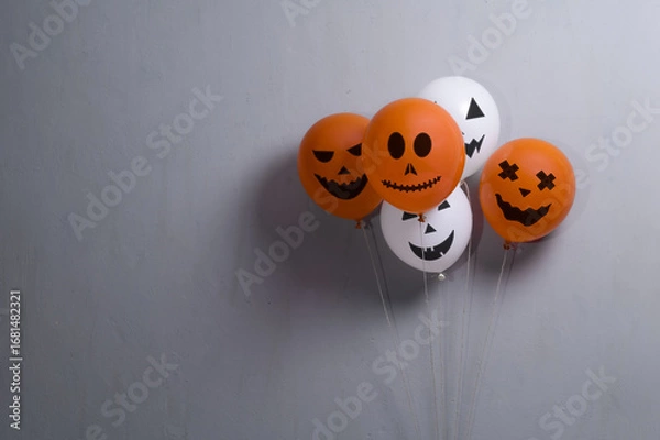 Fototapeta Orange and white balloons for Halloween party on gray background. Space for text