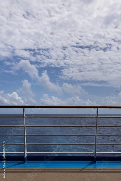 Obraz Beautiful ocean horizon view from cruise ship deck calm seas and whimsical cloudscape on bright day, Vertical image.