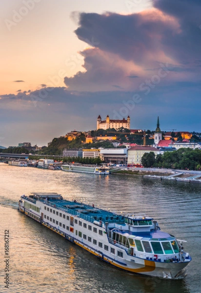 Fototapeta Cityscape of Bratislava, Slovakia at Sunset as Seen from a Bridge over Danube River with a Passenger Ship towards Btatislava Castle
