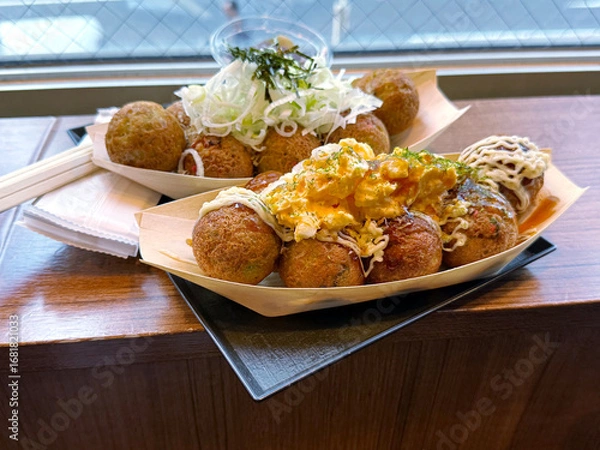 Fototapeta Fried octopus balls takoyaki snack with egg omelet and onion garnish. Asian street food concept. Handheld mobile photo, selective focus, non AI