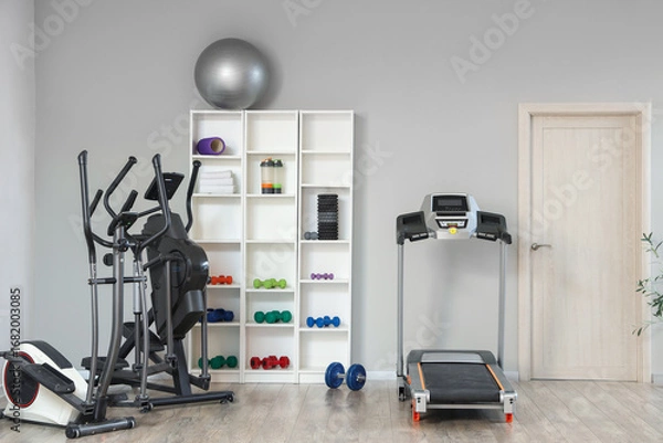 Fototapeta Interior of gym with shelf unit, sports equipment and door