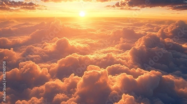 Fototapeta An aerial perspective captures a warm, sunlit sky over a fluffy sea of clouds at dawn or dusk, bathed in golden hues