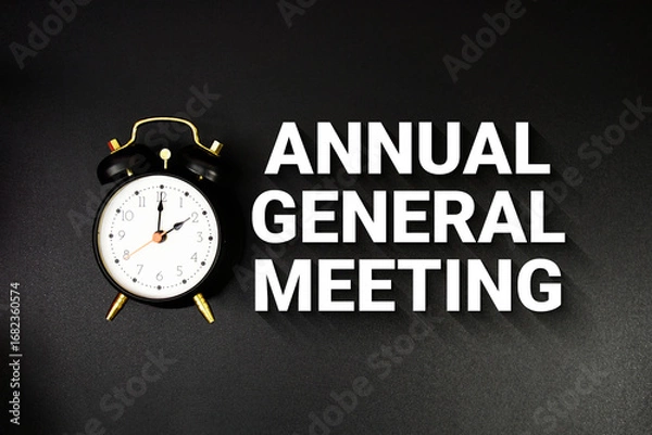 Obraz Annual General Meeting text with alarm clock on black background