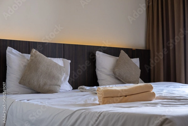 Fototapeta Comfortable hotel mattress with crisp white bedding symbolizing cleanliness and relaxation