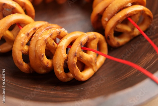 Fototapeta Pretzel cookies tied with red string in bowl