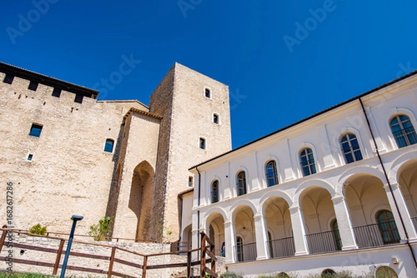 Fototapeta Rocca Albornoziana Fortress towering over Spoleto, showcasing medieval architecture and the charm of Umbria, Italy, under a clear blue summer sky