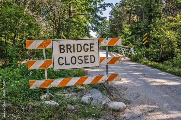 Fototapeta Bridge Closed Sign has been moved to the side of the road and now the bridge is both closed and open causing confusion