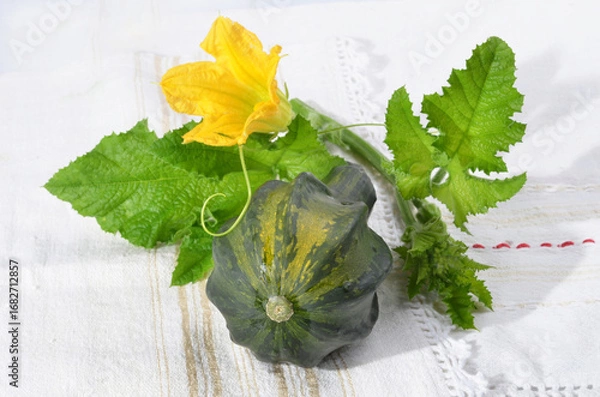 Fototapeta Decorative small pumpkin, green leaves with color, on a table for background.