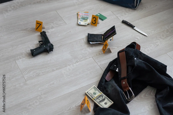 Fototapeta High contrast image of a crime scene with gun and markers on the floor