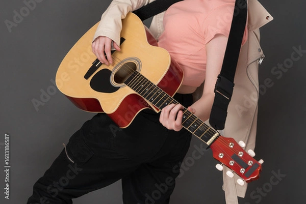Fototapeta Unrecognizable woman guitarist playing her Spanish six string acoustic guitar and enjoying strumming string instrument during her performance on stage. Stylish and creativity female guitar player