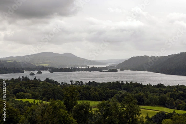 Fototapeta Moody lake scene surrounded by trees, hills and mountains, Lake Windermere, The Lake District, Cumbria, England