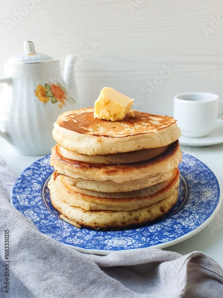Fototapeta golden stack of pancakes with butter on breakfast table