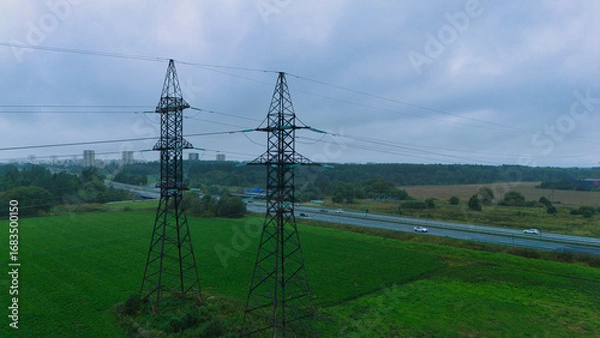 Fototapeta High Voltage Power Lines over Highway - Aerial Drone View