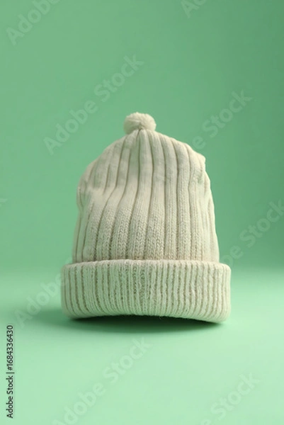 Fototapeta Cream White Knit Beanie Hat with Pom Pom on Light Green Background