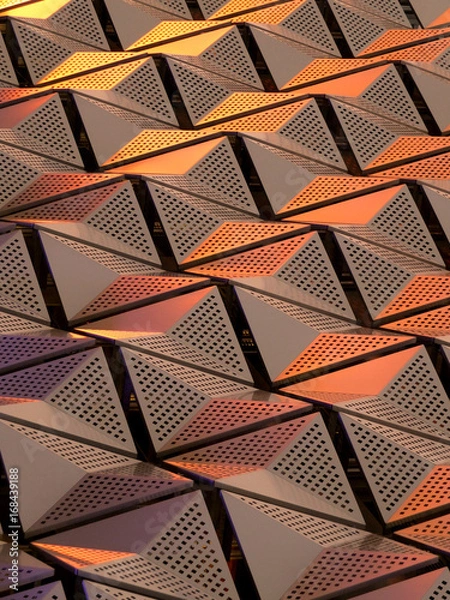 Fototapeta metallic geometric cladding or panels in copper and gold colours with repeating angular pattern