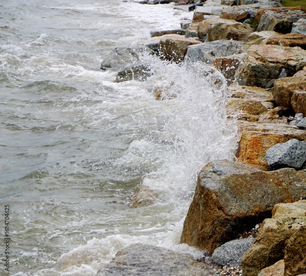 Obraz Splashing sea surf hitting rocks on the beach