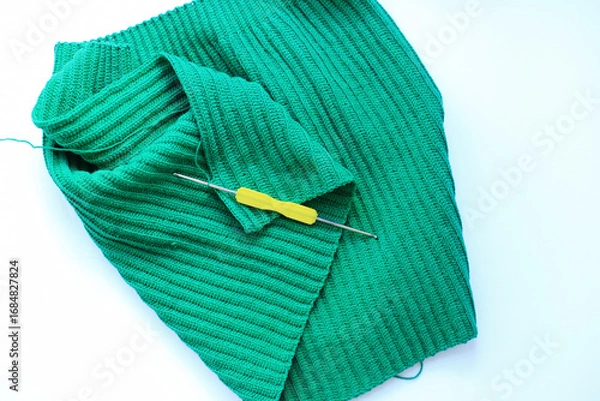 Fototapeta a beautifully crocheted green fabric set against a crisp white background. the intricate patterns and craftsmanship of the crochet work