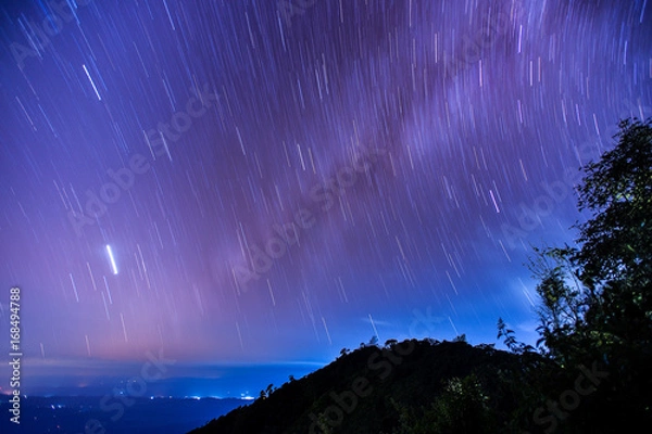Fototapeta Beautiful spiral startrail at Den Chang Non Crest, Pha Peung, Pua, Nan, Thailand.  Fantastic star timelapse with mountain background.