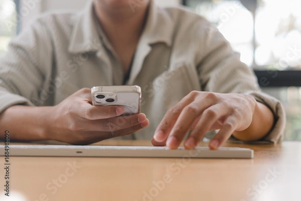 Fototapeta man using smartphone, symbolizing mobile lifestyle, online communication, social media, digital technology, and internet connectivity for modern business, finance and daily life.