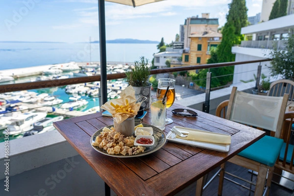 Obraz eating fried squid calamari with a sea view from balcony in croatia with drinks