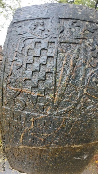 Obraz  Historic gravestone with intricate carvings and engravings displayed in the open area of the Chapel of St. Catherine, Old Goa