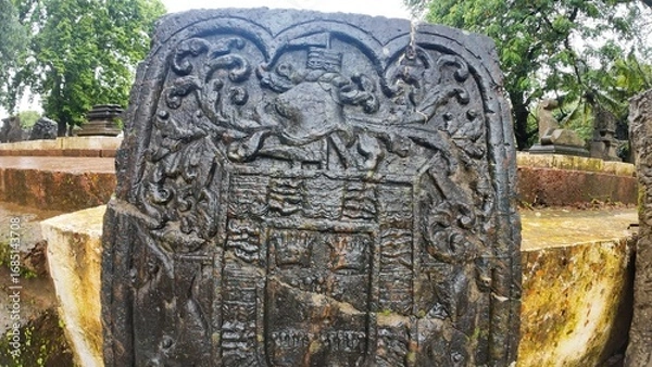 Obraz  Historic gravestone with intricate carvings and engravings displayed in the open area of the Chapel of St. Catherine, Old Goa
