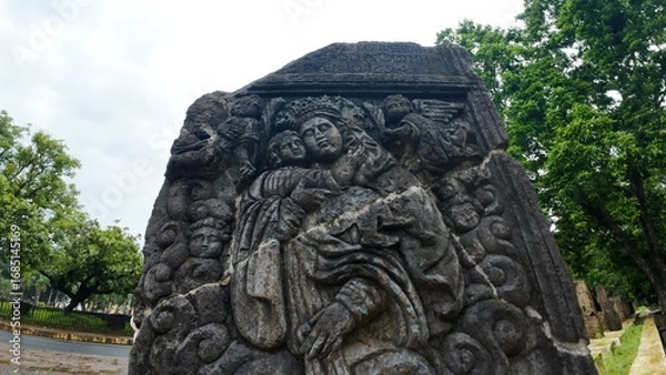 Obraz  Historic gravestone with intricate carvings and engravings displayed in the open area of the Chapel of St. Catherine, Old Goa