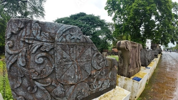 Obraz  Historic gravestone with intricate carvings and engravings displayed in the open area of the Chapel of St. Catherine, Old Goa
