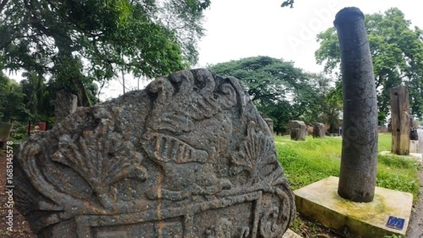 Obraz  Historic gravestone with intricate carvings and engravings displayed in the open area of the Chapel of St. Catherine, Old Goa