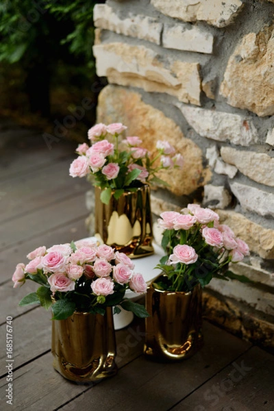 Obraz Large pink roses in golden vases on an open veranda. Photo zone, on-site registration, banquet.
