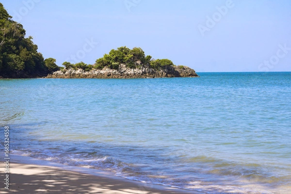 Fototapeta Serene ocean wave flowing over pristine white beach