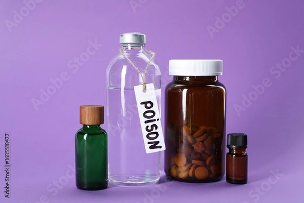 Fototapeta Glass bottles with poisons on violet background
