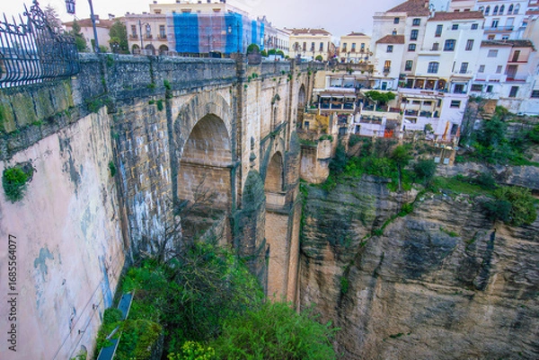 Fototapeta Close up of the historic Puente Nuevo bridge and surrounding buildings in the picturesque town of Ronda Spain showing its impressive arches and the deep gorge.
