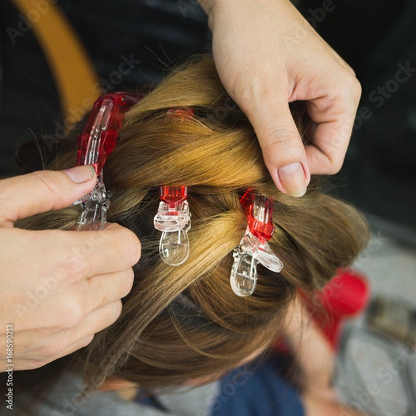 Fototapeta Hairdresser rolls hair customers before dryed