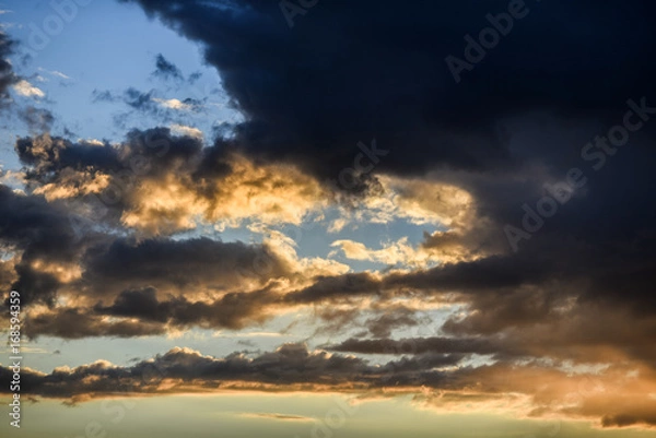 Fototapeta Cloudy sky during sunset in blue and yellow