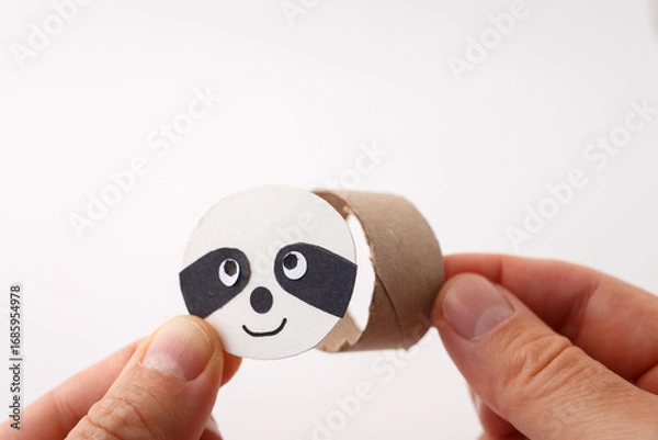 Fototapeta Close-up of DIY sloth face assembly using recycled paper roll, ideal for schools, teachers, homeschooling content, creative learning kits, eco education, step-by-step activities,