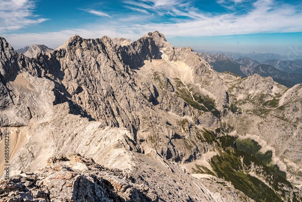 Fototapeta Scenic View Of Zugspitze And Jubilee Ridge From Via Ferrata Alpspitze: Rugged Rocky Peaks Of The Bavarian Alps Under Clear Blue Sky