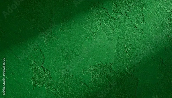 Fototapeta Textured emerald green wall with a diagonal shadow cutting across the top