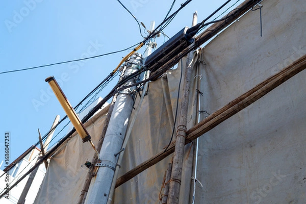 Obraz 足場丸太を番線で固定して遮蔽シートを掛けた様子