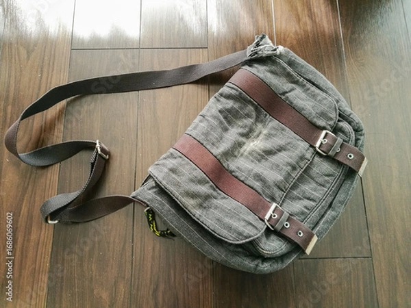 Obraz 使い込まれたショルダーバッグが床に置かれている風景